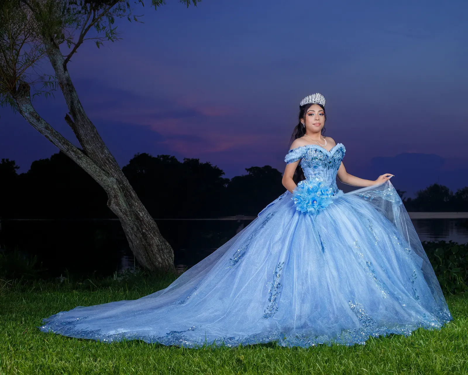 Quinceañera con vestido azul durante una sesión exterior al anochecer