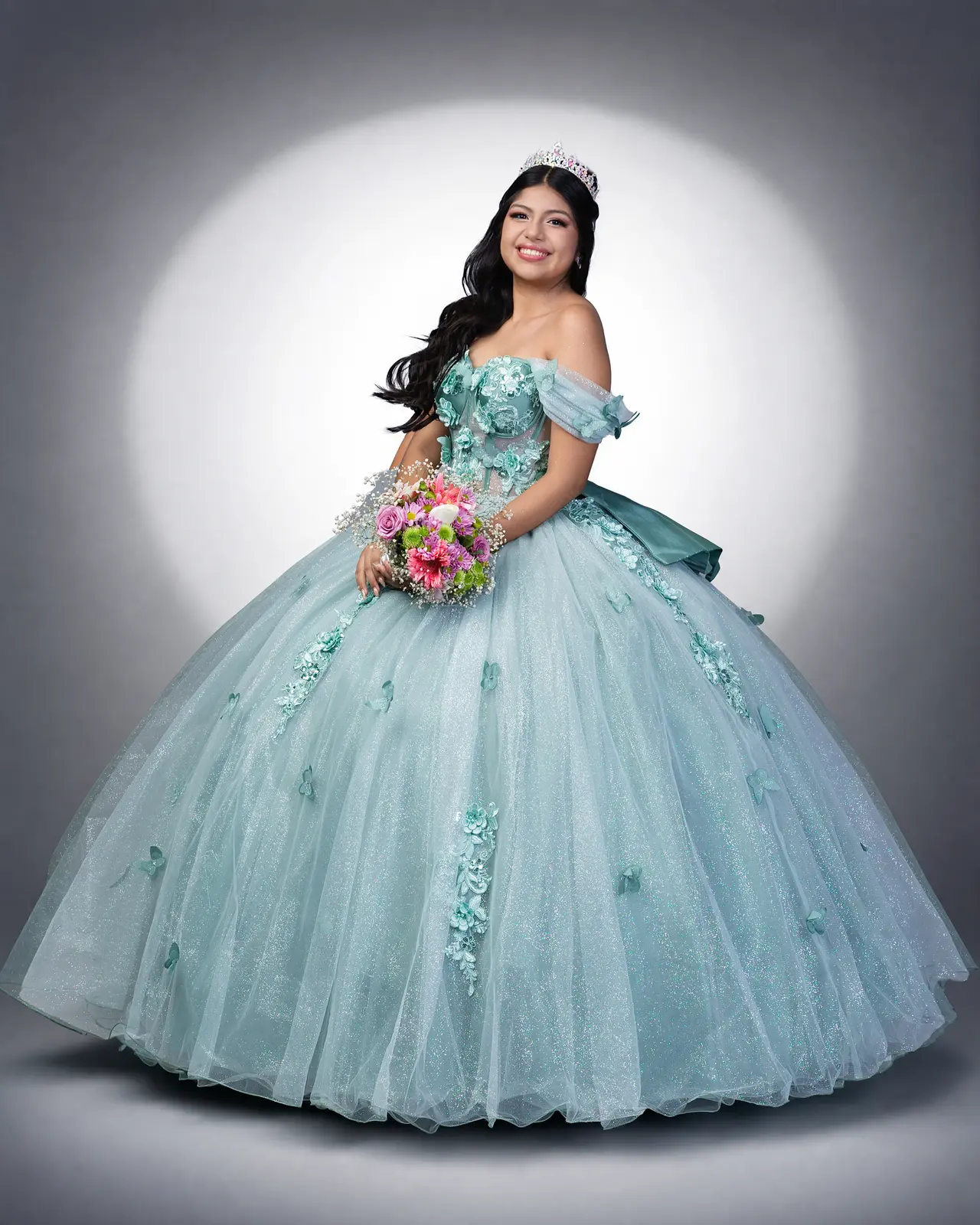 Quinceañera con vestido verde menta en retrato de estudio
